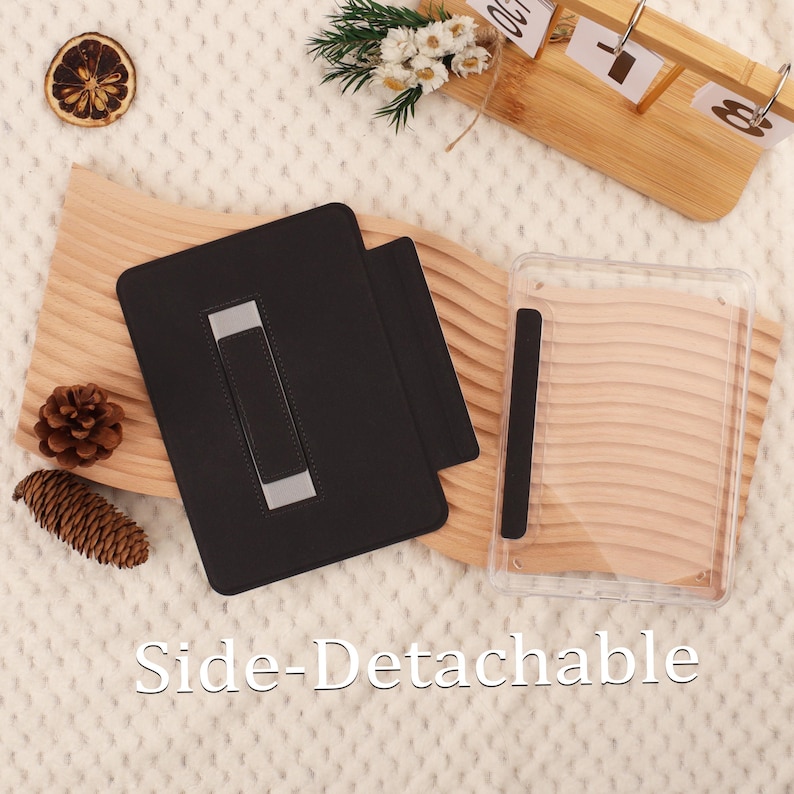 May include: Black tablet case with a silver stand and a clear protective cover. The text "Side-Detachable" is displayed at the bottom. The case is shown on a wooden surface with decorative elements.