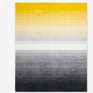 May include: A rectangular area rug featuring a horizontal gradient pattern that transitions from a vibrant yellow at the top, through shades of cream and light gray, to a deep charcoal black at the bottom, with a textured, linear striped appearance.