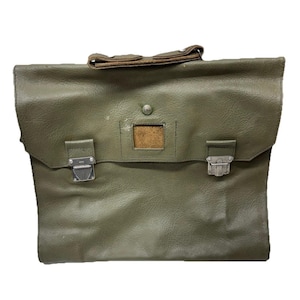 May include: Olive green leather briefcase with a flap closure and two metal clasps. The bag has a brown leather handle and a small rectangular window. The leather has a textured appearance.