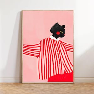 以下が含まれることがあります： 赤い鼻と黄色の目を持つ、様式化された黒猫が描かれた額入りのアートプリント。 猫は赤と白のストライプのシャツと赤いズボンを着用し、ピンクの背景に配置されています。 このアートワークは、気まぐれでモダンな美学を持っています。