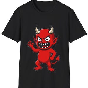 May include: Black t-shirt featuring a cartoon devil with red skin, horns, and a tail. The devil has an angry expression with sharp teeth and is waving one hand. The design is centered on the shirt.