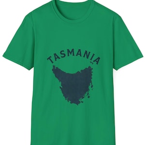 May include: A green t-shirt featuring the word "TASMANIA" above a dark blue outline of the island. The shirt has a crew neck and short sleeves. The design is centered on the chest.