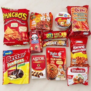 Może przedstawiać: Kolekcja różnych opakowań przekąsek, w tym chipsy tortilla Panchos, pikantne krakersy krewetkowe Oishi, Indomie Mi Goreng, ciasteczka Hello Panda, krakersy Ritz Kaya Butter, Better Fun Bites, czekoladowe rurki Astor, przekąski Kata Oma oraz Bihunku.