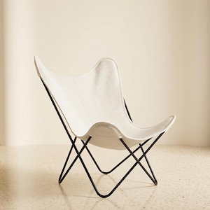 May include: A white butterfly chair with a black metal frame. The chair has a curved, sling-style seat and a minimalist design. The chair is designed for indoor use and is a stylish seating option.