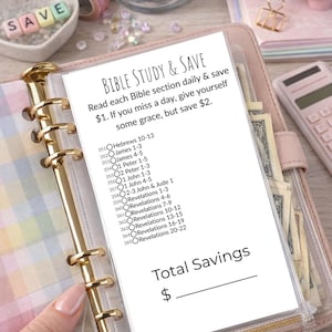 Könnte beinhalten: Ein rosa Ordner mit goldenen Akzenten enthält einen Bibelstudien- und Spar-Tracker. Der Text "Bible Study & Save" steht oben, mit Anweisungen zum täglichen Sparen von 1 €. Der Tracker listet Bibelabschnitte und einen Bereich zur Berechnung der Gesamtersparnisse.