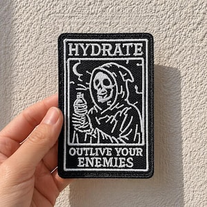 May include: Black and white embroidered patch with the text "HYDRATE" at the top and "OUTLIVE YOUR ENEMIES" at the bottom. The patch features a grim reaper-like figure holding a water bottle.