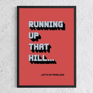 Könnte beinhalten: Gerahmter Kunstdruck mit rotem Hintergrund und den Worten "RUNNING UP THAT HILL...WITH NO PROBLEMS" in grauen und schwarzen Blockbuchstaben. Das Kunstwerk befindet sich in einem schwarzen Rahmen.