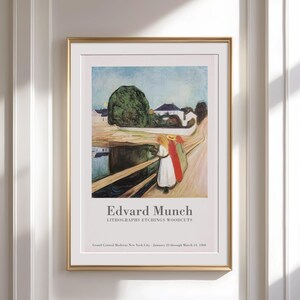 Könnte beinhalten: Gerahmter Kunstdruck einer Lithographie von Edvard Munch. Das Kunstwerk zeigt Figuren auf einer Brücke mit Landschaft im Hintergrund. Der Druck ist in einem goldenen Rahmen und enthält den Text "Edvard Munch" und "LITHOGRAPHIEN RADIERUNGEN HOLZSCHNITTE".