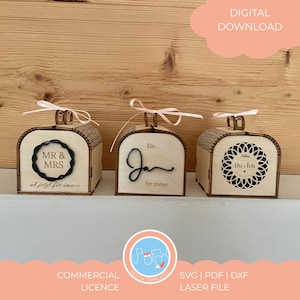 Può includere: Tre scatole di legno con coperchi ad arco, ognuna con un design e un testo diversi. Le scatole hanno una finitura in legno chiaro e sono decorate con elementi decorativi e nastri. Il testo include "MR & MRS", "Ein Jan für immer" e "Du + Ich".