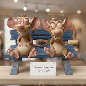 Może przedstawiać: Dwie fantazyjne figurki myszy z dużymi uszami i zamkniętymi oczami siedzą na niebieskiej drewnianej ławce. Myszki są jasnobrązowe z różowymi uszami i nosami. Z przodu znak: "Collectible Companions - A perfect gift!"