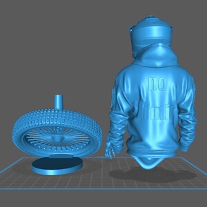 May include: A light blue 3D rendering of a motorcycle wheel and a figure wearing a hoodie. The wheel has a tire with a detailed tread pattern and a central hub. The hoodie has the text "NO LIMIT" on the back.