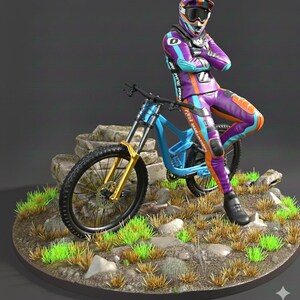 May include: A figurine of a mountain biker in a purple, orange, and blue racing suit and helmet, leaning against a blue and gold mountain bike. The bike is on a rocky terrain with green grass.