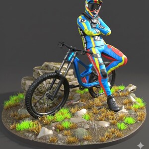 May include: A blue mountain bike with black tires and a rider in a colorful racing suit. The rider is wearing a helmet with goggles and is leaning against the bike. The bike is on a circular base with grass and rocks.