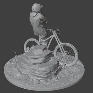 May include: A gray sculpture of a mountain biker on a bicycle, posed on a rocky terrain. The biker is wearing a helmet and protective gear. The bicycle has large tires and suspension. The sculpture is on a circular base.