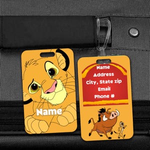 May include: Two rectangular luggage tags. One features a cartoon lion with the word "Name" below. The other tag has a red and yellow design with the words "Name, Address, City, State zip, Email, Phone #" and a cartoon warthog and meerkat.