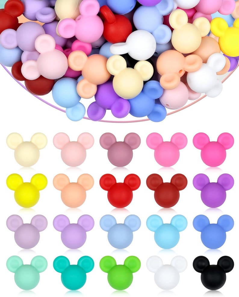 Puede incluir: Una colecci&oacute;n de cuentas de silicona con forma de rat&oacute;n, de colores vivos, incluyendo rosa, azul, amarillo y morado. Las cuentas est&aacute;n dispuestas en un mont&oacute;n y tambi&eacute;n en filas. Estas cuentas son adecuadas para manualidades y la fabricaci&oacute;n de joyas.