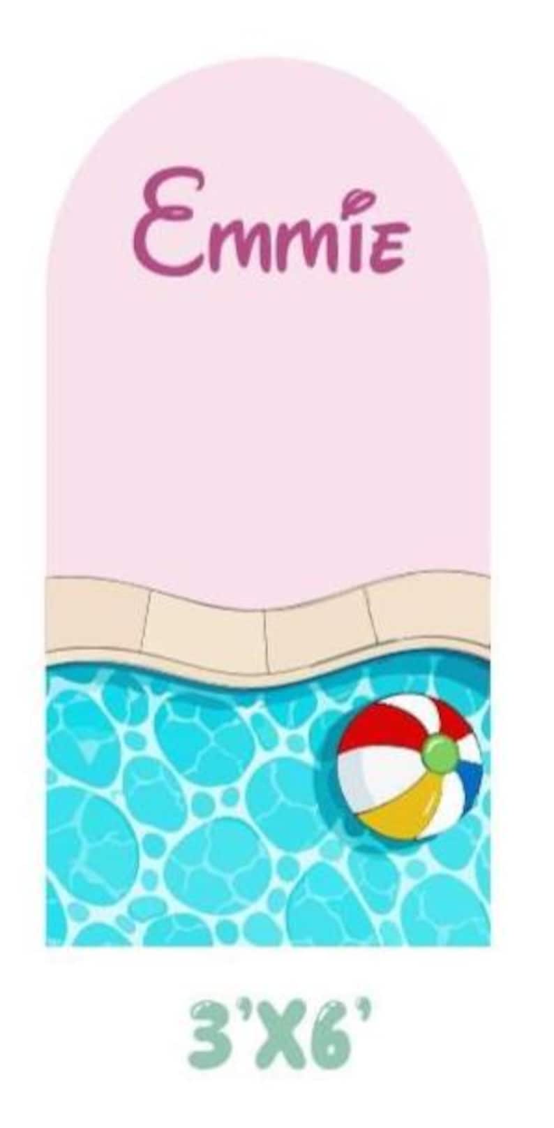 May include: An arched sign featuring a light pink upper section with the name Emmie in dark pink script. Below is a beige pool coping edge and a blue swimming pool with a multi-colored beach ball. The text 3'X6' is printed at the bottom.