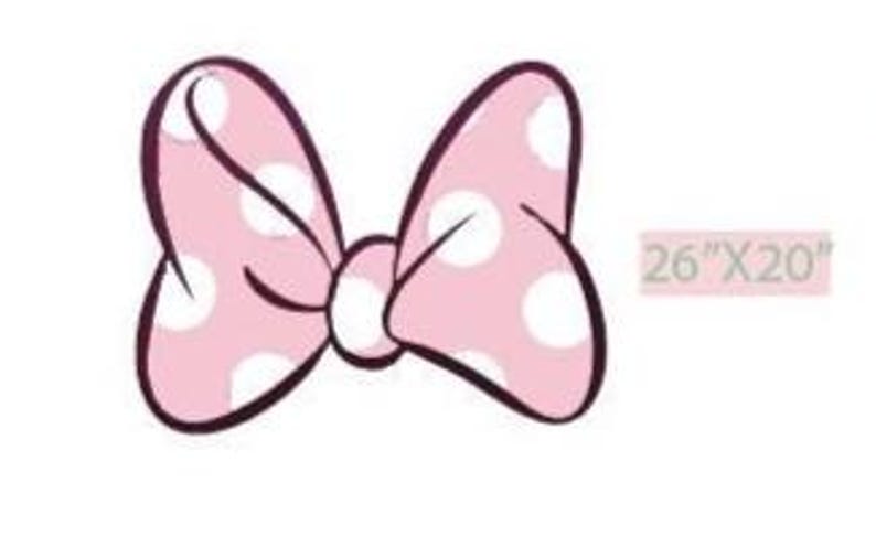 Puede incluir: Un lazo rosa con lunares blancos y contornos negros. El lazo mide 66 cm de ancho y 51 cm de alto. El fondo es blanco.