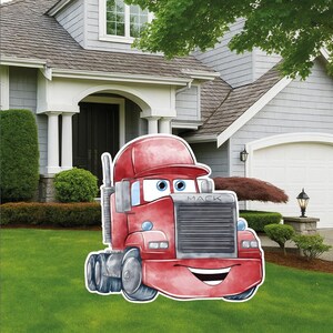 May include: A red cartoon truck yard sign featuring a smiling face, large eyes, and a grey grille with the word MACK printed on the front. The truck has a red cab, a vertical exhaust pipe, and black wheels, designed as a flat decorative cutout.