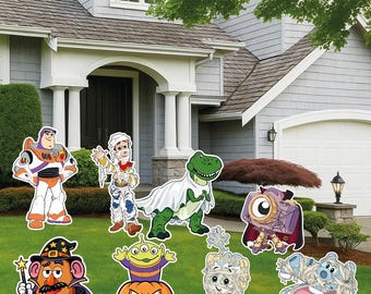 May include: A collection of eight colorful yard signs featuring cartoon characters dressed in Halloween costumes, including a space ranger, a mummy cowboy, a dinosaur in a ghost sheet, a cyclops, a wizard potato, an alien in a pumpkin, and mummies.