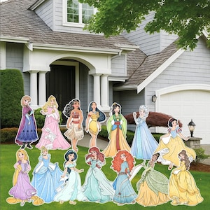 May include: A collection of colorful, stand-up character cutouts of various princesses, displayed on a green lawn in front of a house. The cutouts feature detailed illustrations of the princesses in their iconic gowns and outfits.