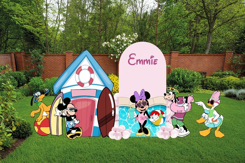 May include: A decorative party display featuring a blue and white beach hut, a pink arch backdrop with the name Emmie, and cutouts of Mickey Mouse, Minnie Mouse, Pluto, Goofy, and Daisy Duck. The scene includes surfboards, a beach ball, and pool.