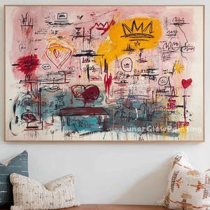 May include: Abstract art painting with a wooden frame. The artwork features a mix of colors, including pink, yellow, red, and blue, with scribbled lines and shapes. A brown leather bench with wooden legs is below the painting, with pillows and boots.