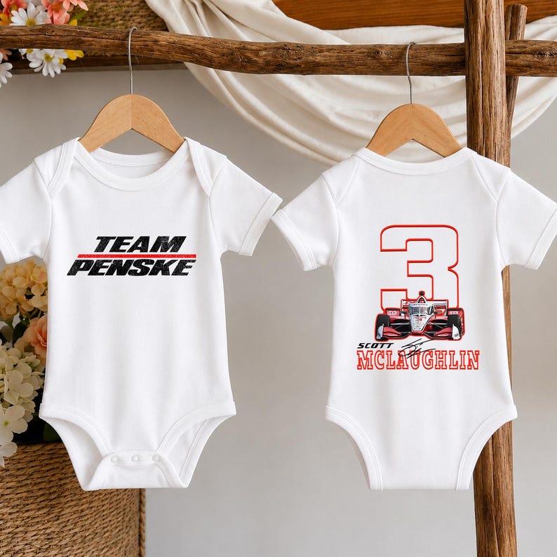 Puede incluir: Dos bodies blancos de manga corta para beb&eacute;. El body de la izquierda presenta el texto negro "TEAM PENSKE" con una l&iacute;nea roja. El body de la derecha muestra un n&uacute;mero "3" rojo grande, un coche de carreras rojo y el texto "SCOTT MCLAUGHLIN".