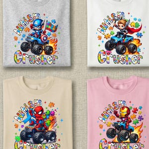 Puede incluir: Cuatro camisetas con gr&aacute;ficos de superh&eacute;roes. Cada camiseta presenta un superh&eacute;roe montado en un monster truck con la palabra "Crusher" debajo. Las camisetas son grises, blancas, beige y rosas. El texto "Autismo" est&aacute; encima del superh&eacute;roe.