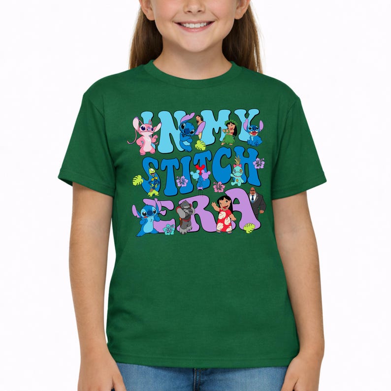 Pode incluir: Uma t-shirt de manga curta verde-escura com uma impress&atilde;o gr&aacute;fica com o texto "IN MY STITCH ERA" em letras azul-claras e roxas. O design inclui v&aacute;rias personagens de desenhos animados da franquia Lilo e Stitch.