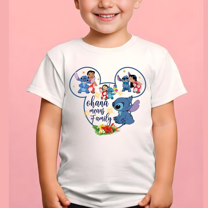 May include: A white short-sleeved t-shirt featuring a graphic of Stitch and Lilo inside a Mickey Mouse ear outline. The design includes the text "ohana means Family" in blue script, surrounded by small yellow stars and tropical hibiscus flowers.