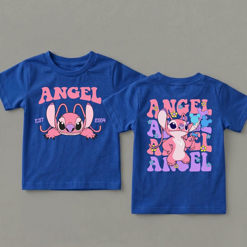 May include: A royal blue short-sleeve t-shirt featuring a pink character graphic. The front displays the text ANGEL EST 2004. The back shows the character standing among repeating ANGEL text and small flower icons in shades of pink, blue, and yellow.