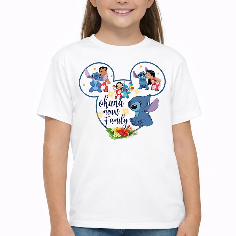 May include: A white short-sleeved t-shirt featuring a graphic of Stitch and Lilo inside a Mickey Mouse ear outline. The design includes the text "ohana means Family" in blue script, surrounded by colorful tropical flowers and small yellow stars.