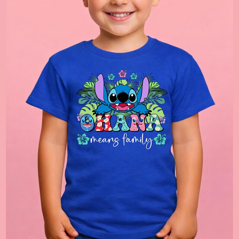 May include: A royal blue short-sleeved t-shirt featuring a graphic of the character Stitch surrounded by green tropical leaves and colorful hibiscus flowers. The text OHANA is printed in a patterned font, followed by the script text means family.