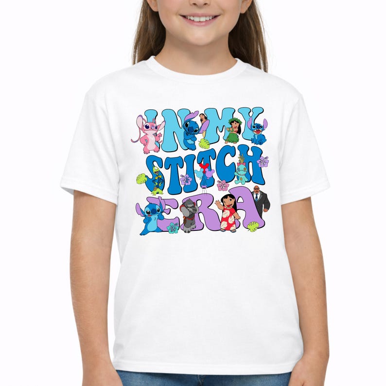 Pode incluir: Uma t-shirt branca de manga curta com uma impress&atilde;o gr&aacute;fica contendo o texto IN MY STITCH ERA em letras de bolha azuis e roxas. O design inclui v&aacute;rias personagens de desenhos animados da franquia Lilo e Stitch e flores tropicais.