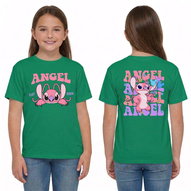 May include: A green t-shirt featuring a pink character graphic. The front displays the text ANGEL EST 2004 with a pink character. The back shows the character surrounded by the repeating text ANGEL and small colourful flower and mouse ear icons.