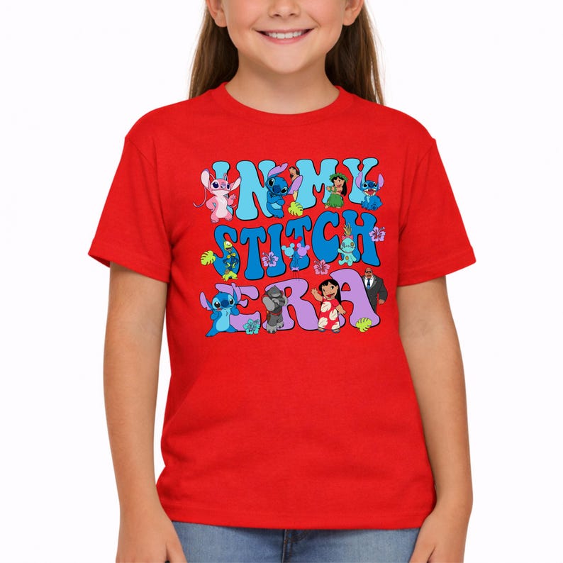 Pode incluir: Uma t-shirt vermelha de manga curta com uma estampa gr&aacute;fica que apresenta o texto "IN MY STITCH ERA" em letras grandes azuis e roxas. O design inclui v&aacute;rias personagens de desenhos animados coloridas, flores tropicais e folhas verdes.