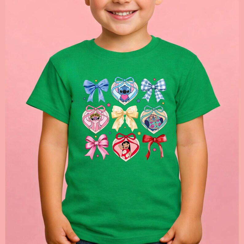 May include: A bright green short-sleeve t-shirt featuring a central graphic print of various bows and heart-shaped frames. The design includes illustrations of Stitch, Angel, and Lilo from Lilo and Stitch, interspersed with blue, pink, and red bows.