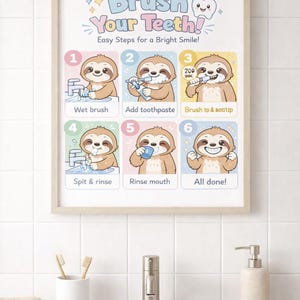 Puede incluir: Un póster enmarcado con el texto "¡Cepíllate los dientes!" e ilustraciones de un perezoso que demuestra los pasos para cepillarse los dientes. El póster está en un baño, encima de un lavabo con cepillos de dientes y un dispensador de jabón.