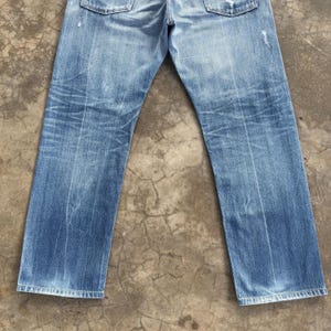Pu&ograve; includere: Jeans in denim blu chiaro con lavaggio sbiadito e dettagli usurati. I jeans hanno un classico design a cinque tasche e una vestibilit&agrave; dritta. Il denim mostra segni di usura, aggiungendo all'estetica vintage.