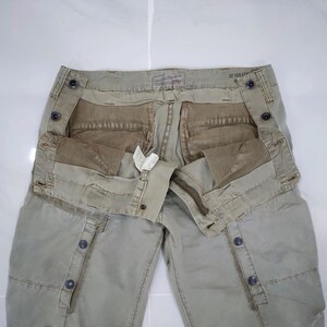 May include: A set of three ceramic mugs with a speckled, cream-colored glaze. Each mug features a different hand-painted floral design in shades of blue, green, and yellow. The mugs have a simple, rounded shape and a comfortable handle.