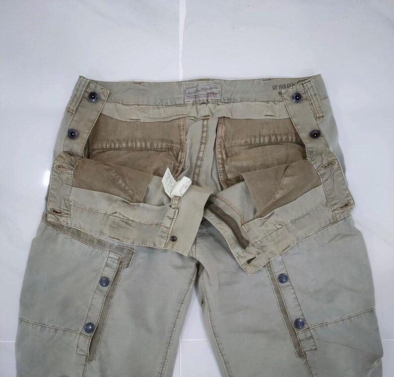 May include: A set of three ceramic mugs with a speckled, cream-colored glaze. Each mug features a different hand-painted floral design in shades of blue, green, and yellow. The mugs have a simple, rounded shape and a comfortable handle.