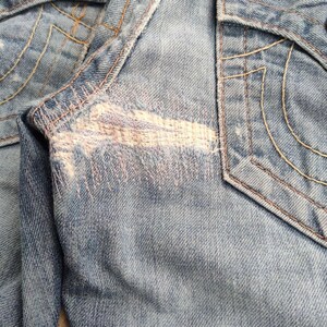 May include: A white ceramic mug with a black handle and the text "But First, Coffee" in a black, handwritten-style font. The mug is on a white surface.