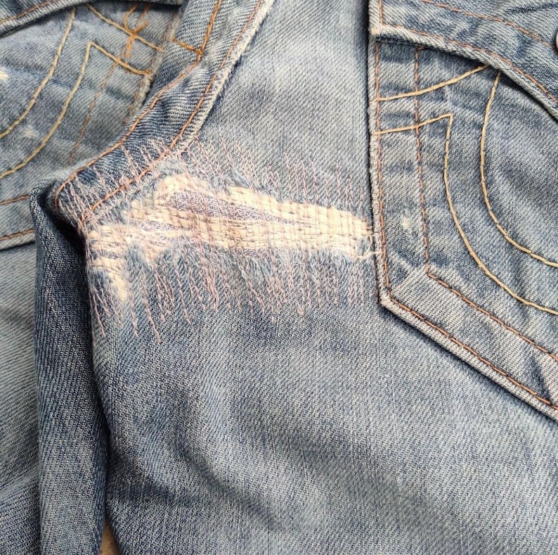 May include: A white ceramic mug with a black handle and the text "But First, Coffee" in a black, handwritten-style font. The mug is on a white surface.