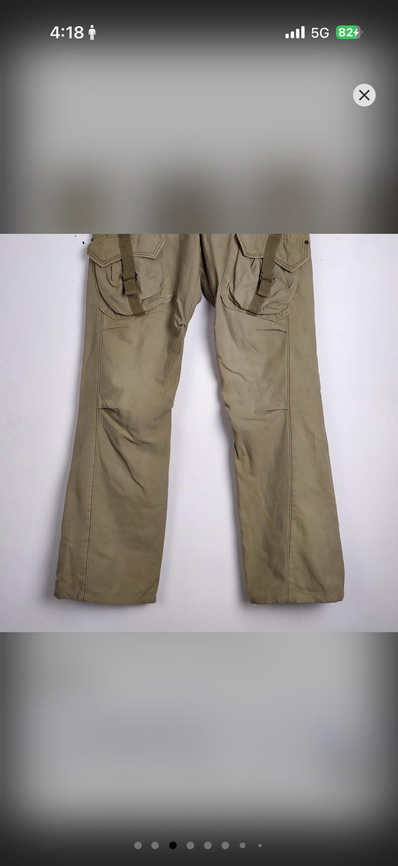 May include: Khaki-colored cargo pants with large pockets and straps. The pants have a relaxed fit and are made of a durable material. The design includes reinforced knees and a straight leg.