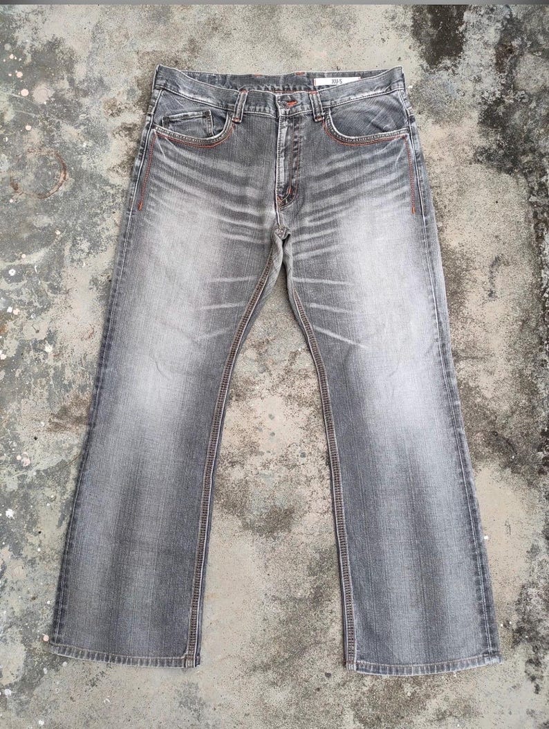K&ouml;nnte beinhalten: Graue Jeans mit verwaschener Optik und leicht ausgestelltem Bein. Die Jeans hat rote N&auml;hte an den S&auml;umen und Taschen. Sie hat ein klassisches F&uuml;nf-Taschen-Design und einen Knopf- und Rei&szlig;verschluss.