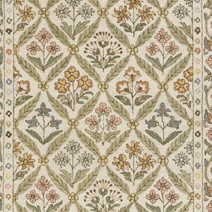 Puede incluir: Primer plano de una alfombra con estampado floral. La alfombra presenta un patrón de diamantes repetido con flores en tonos melocotón, amarillo y azul, sobre un fondo crema. Hojas verdes y acentos amarillos completan el diseño.