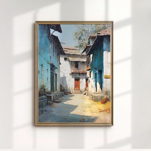 May include: An oil painting in a gold frame depicts a sunlit alleyway between buildings. The buildings are painted in shades of blue and white, with red doors and weathered textures. The artwork evokes a sense of a quiet, historic town.