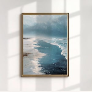 Puede incluir: Pintura de paisaje enmarcada que representa una serena escena costera. La obra presenta una playa con arena blanca, agua turquesa y un cielo nublado. La pintura está encerrada en un marco dorado, añadiendo un toque de elegancia.