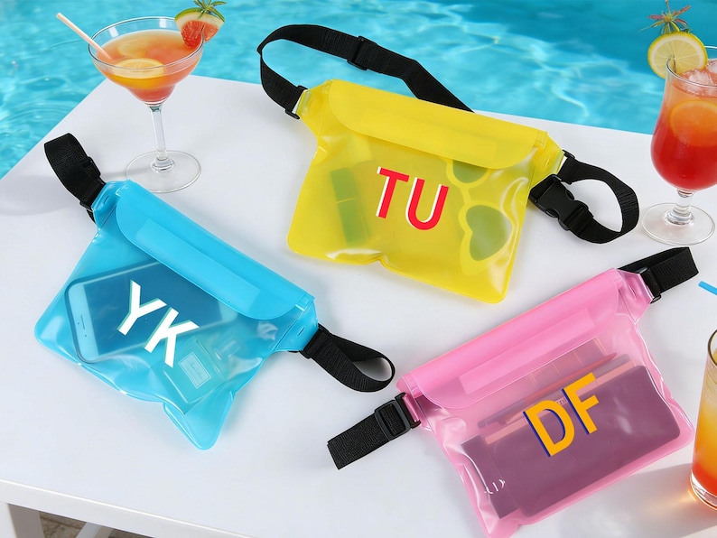 Op de afbeelding: Drie waterdichte heuptassen in blauw, geel en roze. Elke tas heeft een zwarte verstelbare riem en een gesp. De blauwe tas heeft een telefoon met de letters "YK". De gele tas heeft de letters "TU". De roze tas heeft de letters "DF".